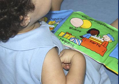 Escuela Infantil Laly niño viendo libro de juguete